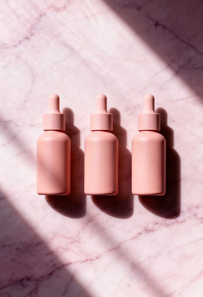 Collection of niacinamide serum bottles styled on a skincare background